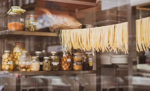 Pasta hanging over the thread with jars of spices