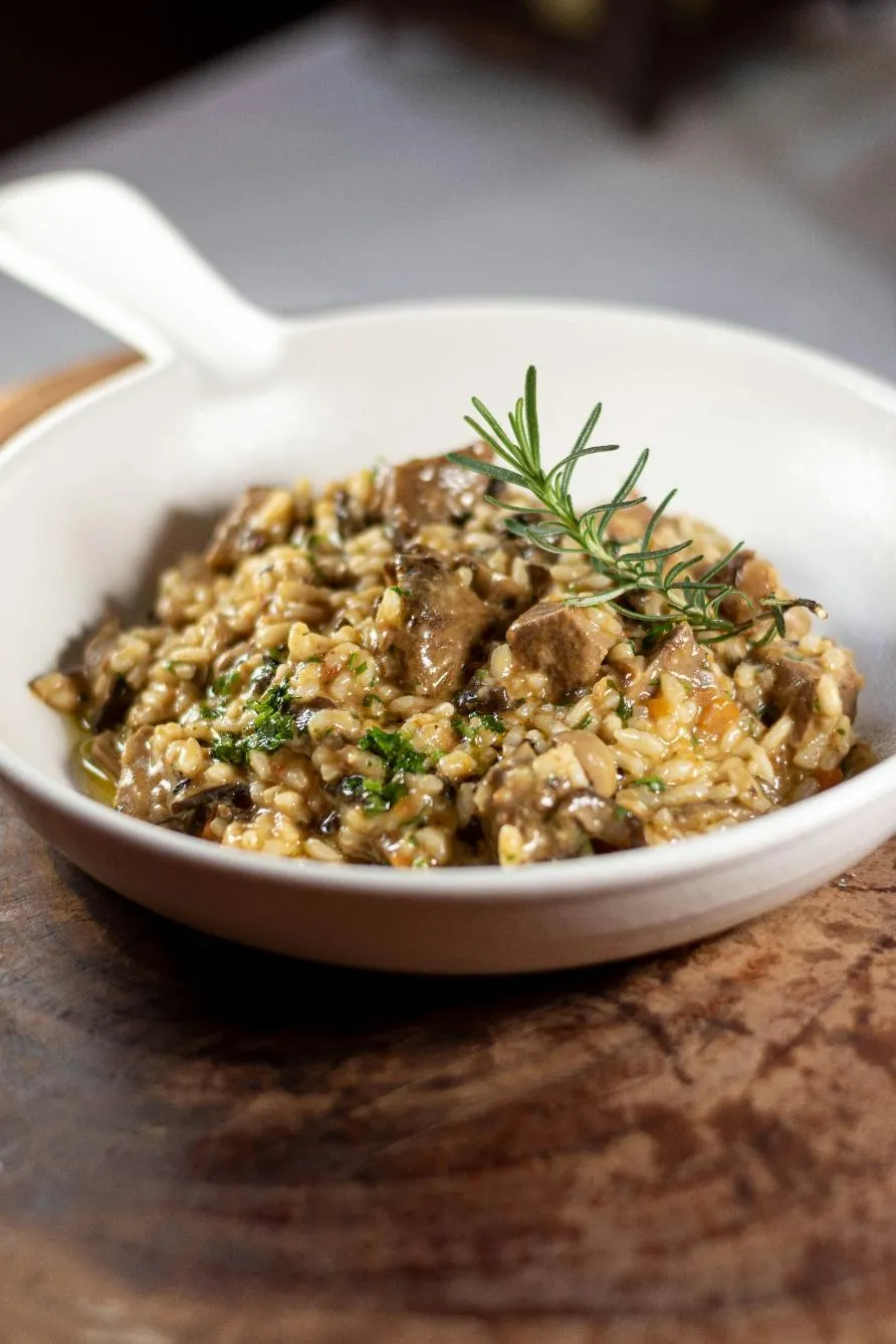 A bowl full of risotto with green garnish on the top