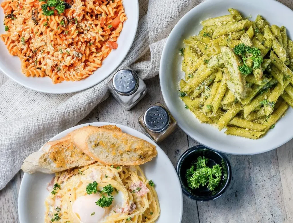 Different types of pasta on the table with salt and pepper shakers