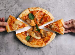 Top-down view of a person holding a sliced authentic Neapolitan pizza