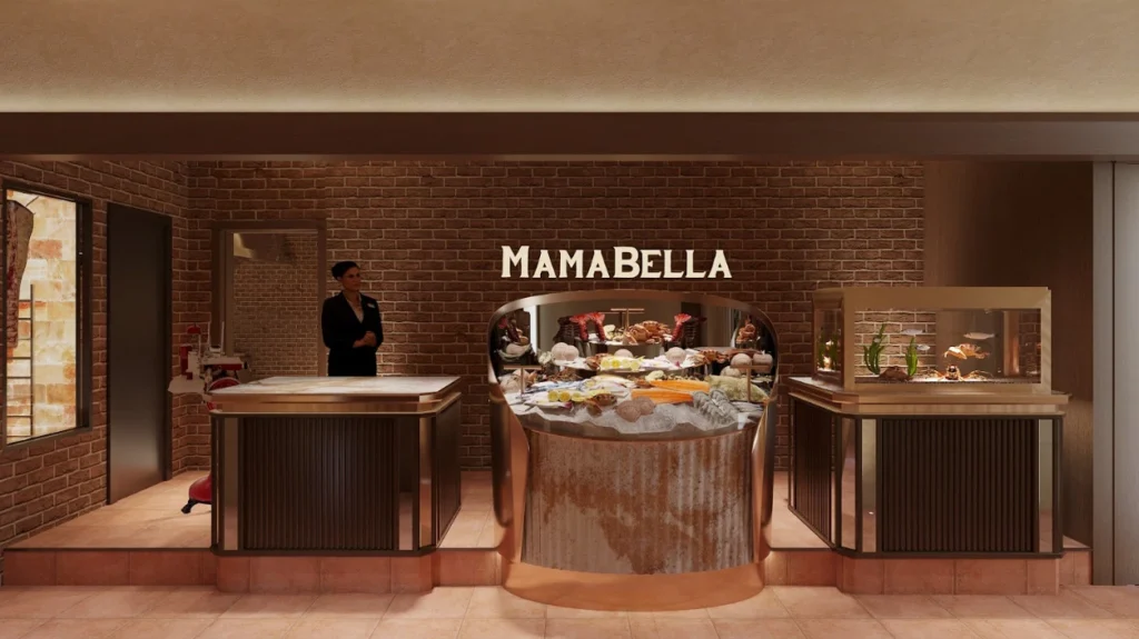 Entrance of a restaurant named “MAMABELLA,” featuring a brick wall backdrop and a central display filled with fresh seafood on ice. A staff member stands beside a counter on the left, while an aquarium-style display with live seafood sits on the right. The space has warm lighting and elegant, modern decor.