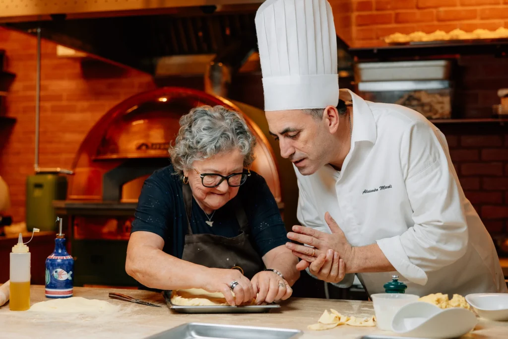 old lady and a chef making food in mama bella kitchen