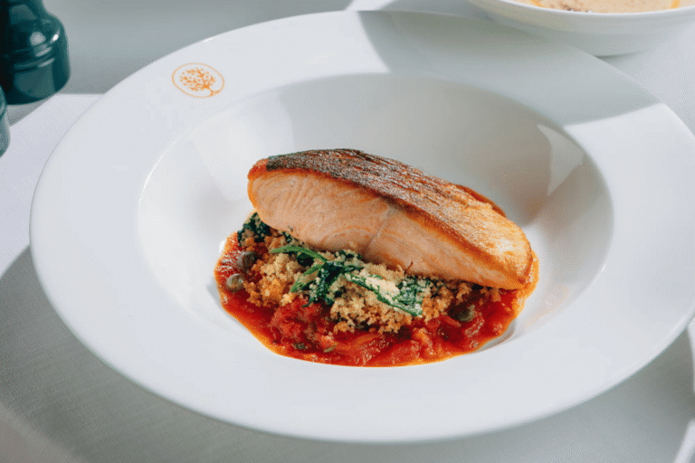 Pan-seared salmon served with tomato sauce, greens and breadcrumbs at Mamabella Italian restaurant.