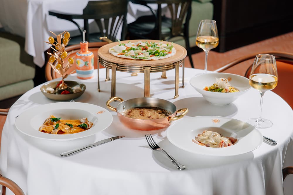 Italian dishes served at Mamabella, featuring fresh pasta, pizza and signature specialties with white wine.