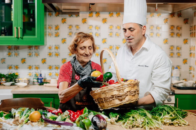Cucina Mamma at Mamabella, featuring a chef and Italian mamma preparing fresh vegetables together in the kitchen.