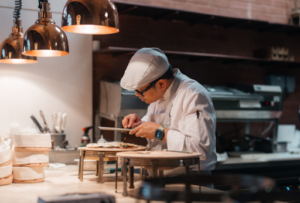 Chef plating a tasting menu course in an Italian restaurant kitchen in Dubai